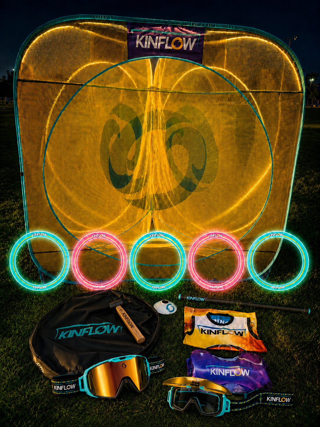The full KinFlow equipment set at night: a lit portal net, five glowing rings, staff, goggles, jerseys and carry bag on a field